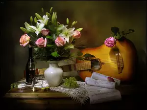 Bukiet kwiatów obok gitary, nut, winogron i wina
