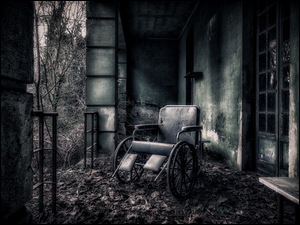 Wózek inwalidzki w zniszczonym pomieszczeniu