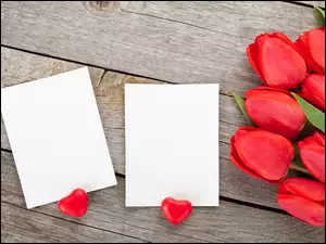 Dwa serduszka koło białych kartek z bukietem tulipanów