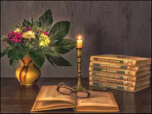 Kwiaty i książki w blasku płonącej świeczki