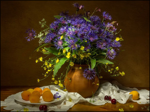 Bukiet polnych kwiatów w wazonie i owoce