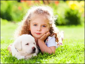 Dziewczyna z małym szczeniakiem na trawniku