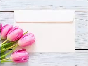 różowe tulipany z kopertą na deskach