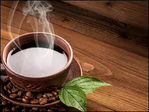 filiżanka gorącej kawy z ziarenkami i listkami mięty