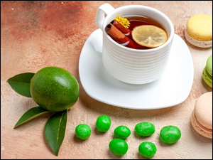 Makaroniki i cukierki przy filiżance herbaty