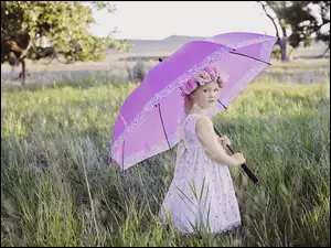 Dziewczynka z letnim parasolem na łące