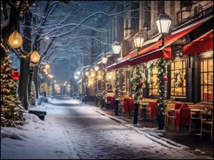 Stoliki pod oświetlonymi udekorowanymi świątecznie oknami restauracji wzdłuż zaśnieżonej ulicy
