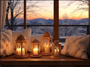 Lampiony obok poduszek na parapecie okna