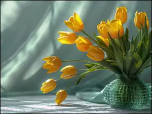 Materiał obok wazonu z żółtymi tulipanami