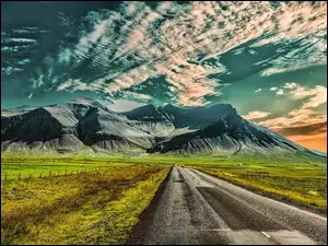 Chmury nad górami i drogą w polu