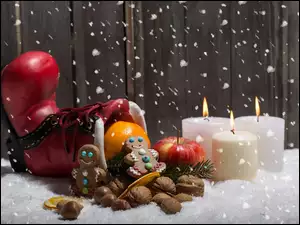 Świąteczna kompozycja z butem Mikołaja i świecami
