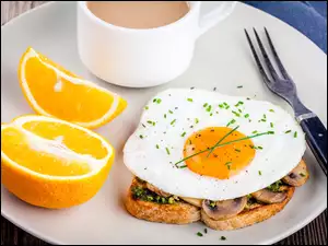 Kanapka z jajkiem sadzonym i kawa na talerzu