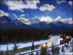 Pociąg przy rzece w zimowym Parku Narodowym Banff w Kanadzie