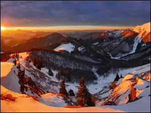 Panorama gór w zimowym krajobrazie z zachodzącym słońcem