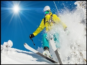 Zimowe promienie słońca rozświetlają zjazd narciarzowi