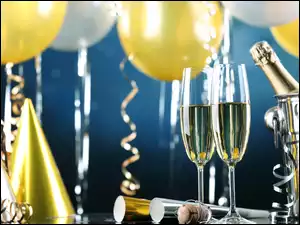 Sylwestrowe balony i serpentyny fruwają pośród kieliszków z szampanem
