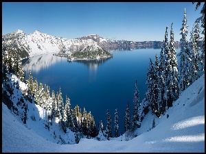 Mała wyspa na jeziorze otoczonym zaśnieżonymi górami i drzewami