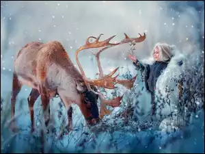 Radosne dziecko z jeleniem w zimowym klimacie