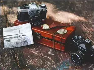 Kolekcja starych aparatów fotograficznych z zegarkiem i szkatułką