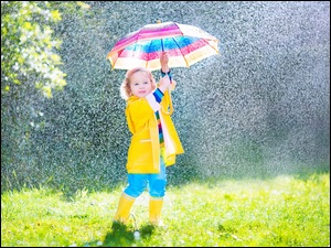 Radosna dziewczynka pod parasolem w deszczu