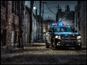 Najszybszy radiowóz policyjny w uliczce pomiędzy kamienicami