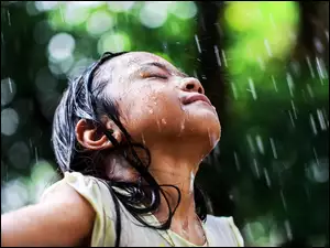 Dziewczynka w deszczu na rozmytym tle