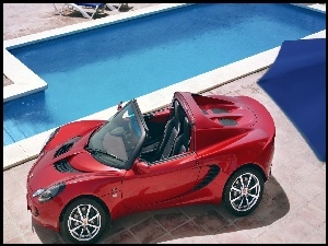 Czerwony Lotus Elise R kabriolet przy basenie
