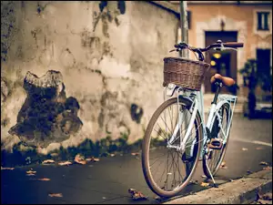 Rower z koszykiem stoi na chodniku