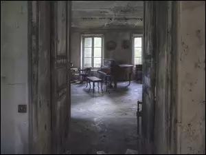 Wnętrze zniszczonego pokoju ze starym krzesłem i fortepianem