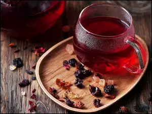 Owocowa herbata w szklance z suszonymi owocami na tacce