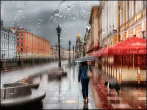 Kobieta chroni sie przed deszczem pod parasolem