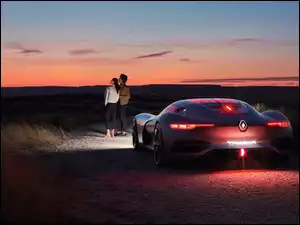Kobieta i mężczyzna stojąc przy samochodzie Renault oglądają zachód słońca