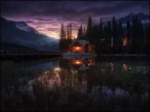 Oświetlony dom nad jeziorem w kanadyjskim Parku Narodowy Banff