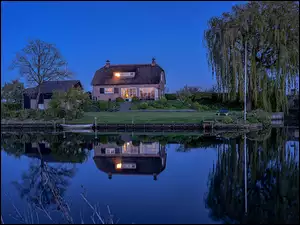 Oświetlony dom nad rzeką w Holandii