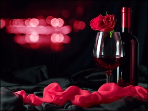 Butelka czerwonego wina z kieliszkiem i różą