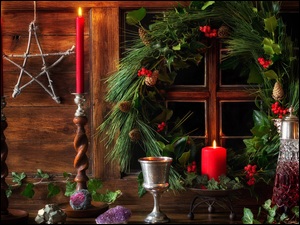 Kompozycja świąteczna w oknie ze świecami i karafką