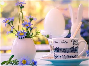 Wielkanocna kompozycja z kwiatami w wazoniku króliczkiem i filiżanką z nutami