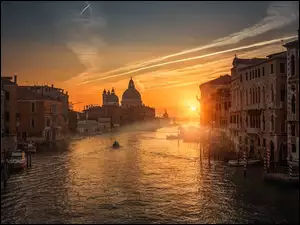 Kanał w Wenecji pomiędzy budynkami w blasku zachodzącego słońca