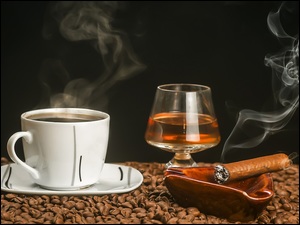 Filiżanka z kawą z kieliszkiem koniaku i dymiącym cygarem w popielniczce