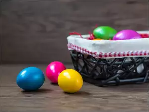 Wielkanocne pisanki w koszyczku i ułożone obok