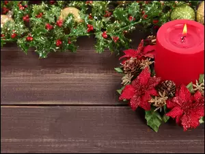 Świeczka w świątecznej dekoracji z gałązkami