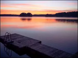 Widok z pomostu na jeziorze na zachód słońca