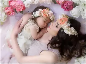 Śpiąca kobieta z małą dziewczynką pośród kwiatów