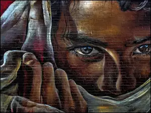 Zasłonięta twarz kobiety z widocznymi oczami w graffiti