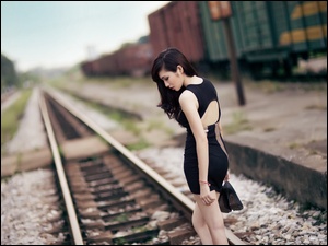 Kobieta Azjatka pozuje na torach kolejowych