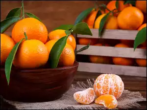 Dojrzałe mandarynki w misce i skrzynce