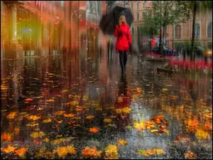 Kobieta pod parasolem na jesiennym spacerze