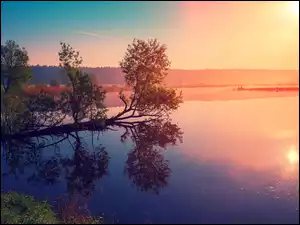 Zamglone jezioro o wschodzie słońca