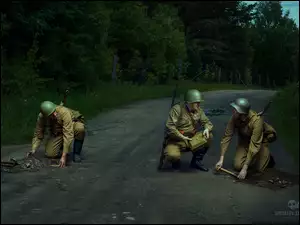 Żołnierze na leśnej drodze szukają min
