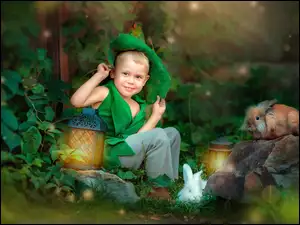 Chłopiec w przebraniu z lampionen i królikami wśród roślin
